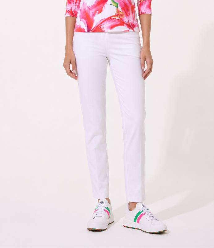 Woman wearing a pink floral shirt and white pants on a white background